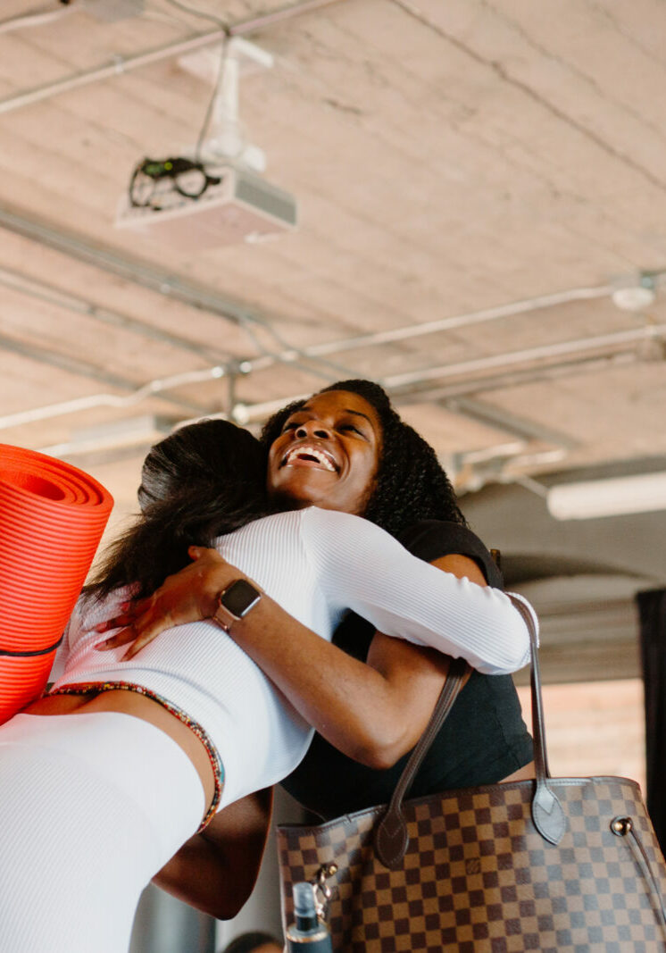 two women hugging after the yoga class