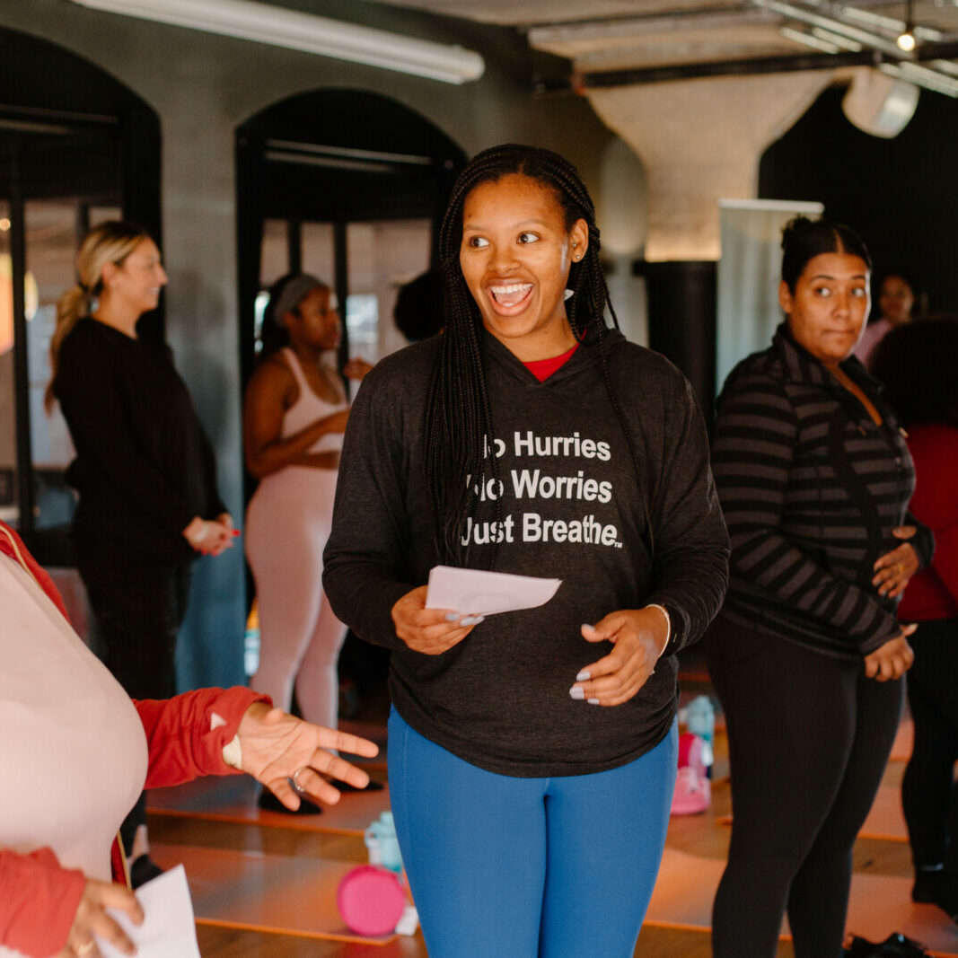 Women interacting and laughing during a yoga class